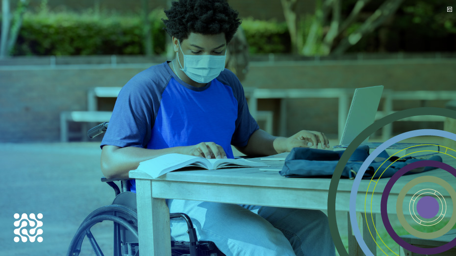 Foto de jovem negro cadeirante lendo um livro